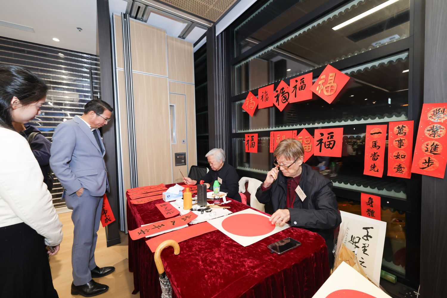 葛量洪教育學院校友會主席李百強先生（右）聯同教大校友及資深視覺藝術教師楊又蓮（左）即席揮毫，撰寫揮春